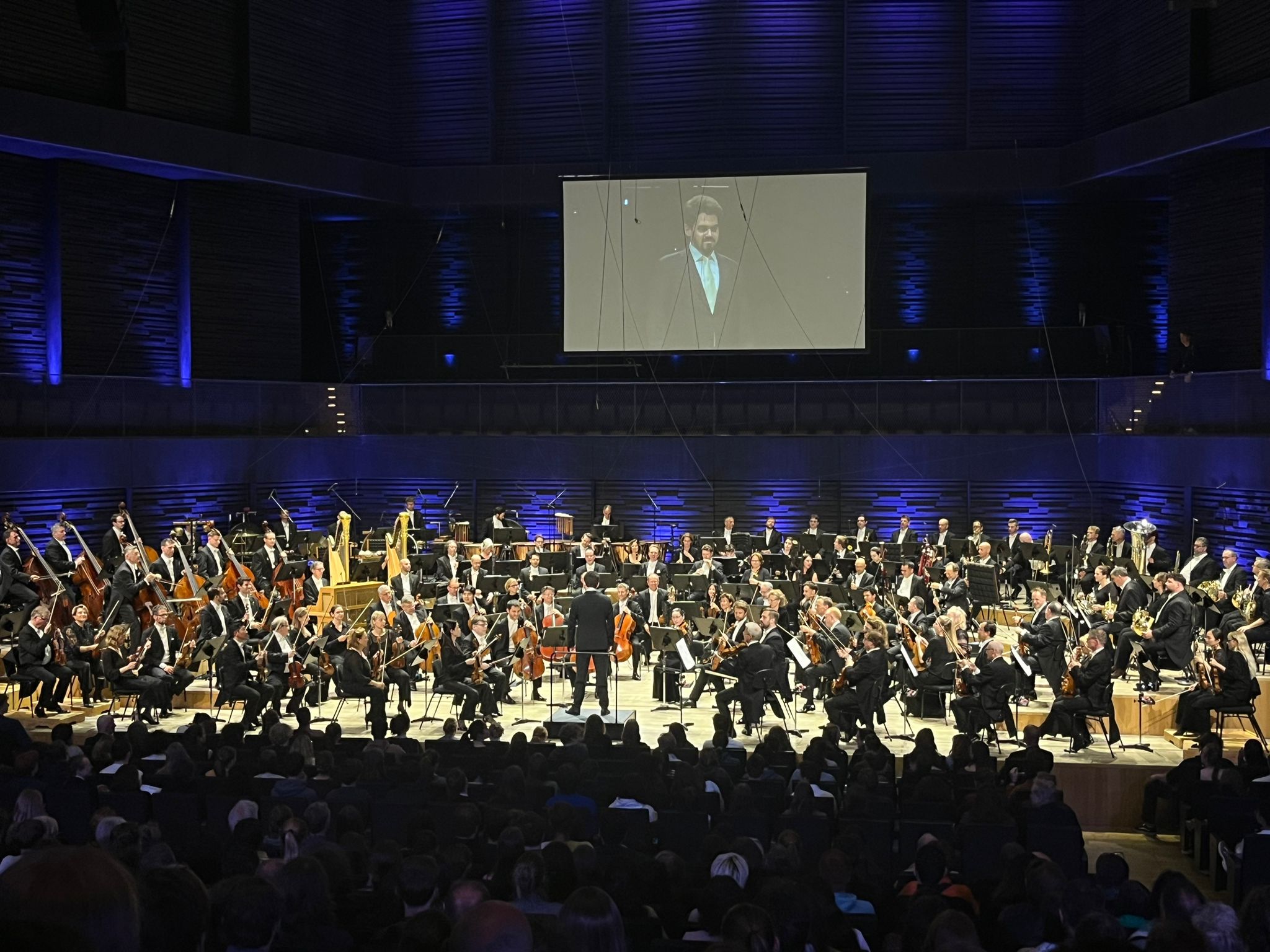 Auf dem Bild sind die Münchner Philharmoniker unter der Leitung von Lahav Shani zu sehen.
