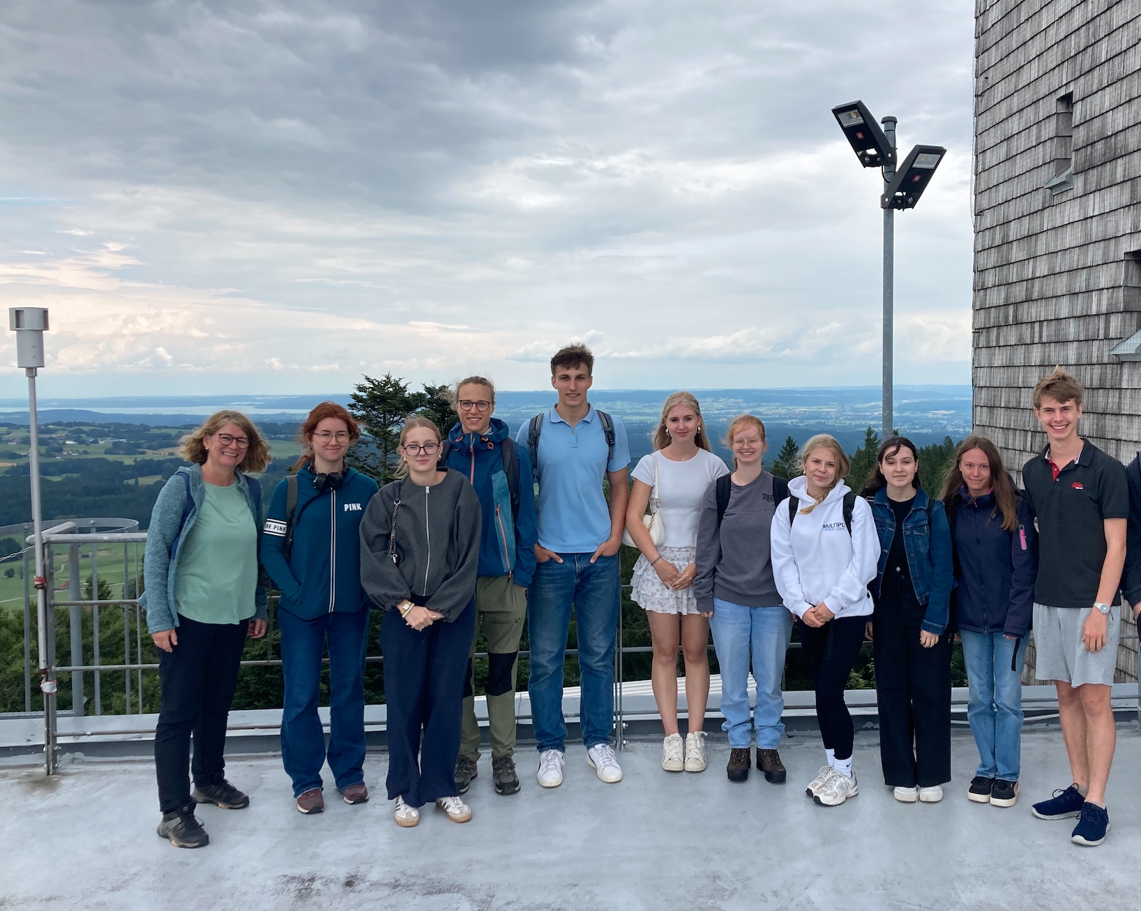 Zu sehen sind Schülerinnen und Schüler des Gymnasiums vor einer Bergkulisse.