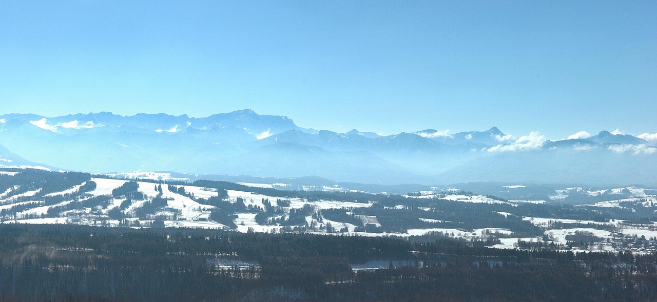 winterliche Landschaft vor der Alpenkulissemit Hochnebel