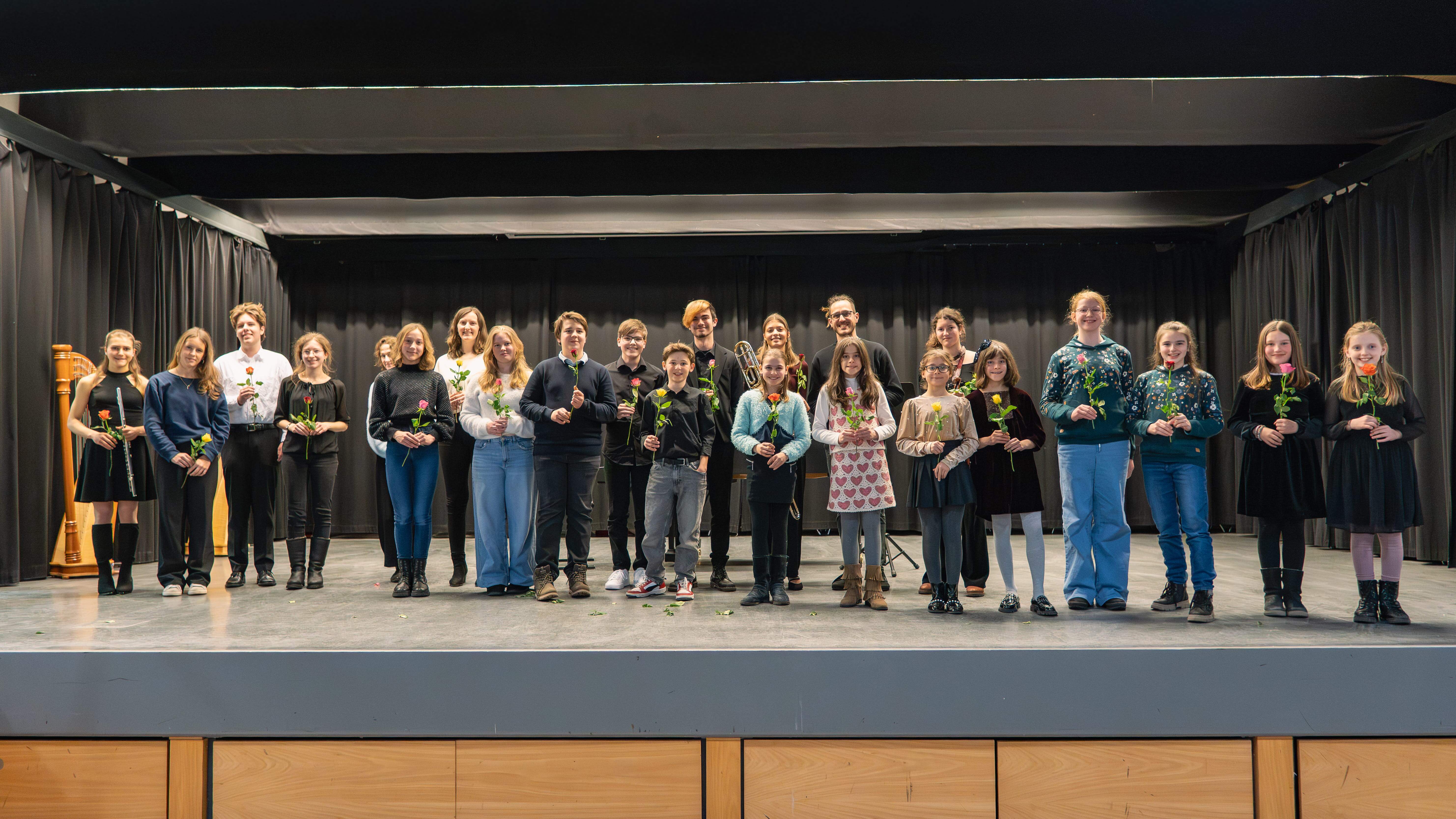 Schülerinnen und Schüler auf der Bühne der Aula bei Musik um 7